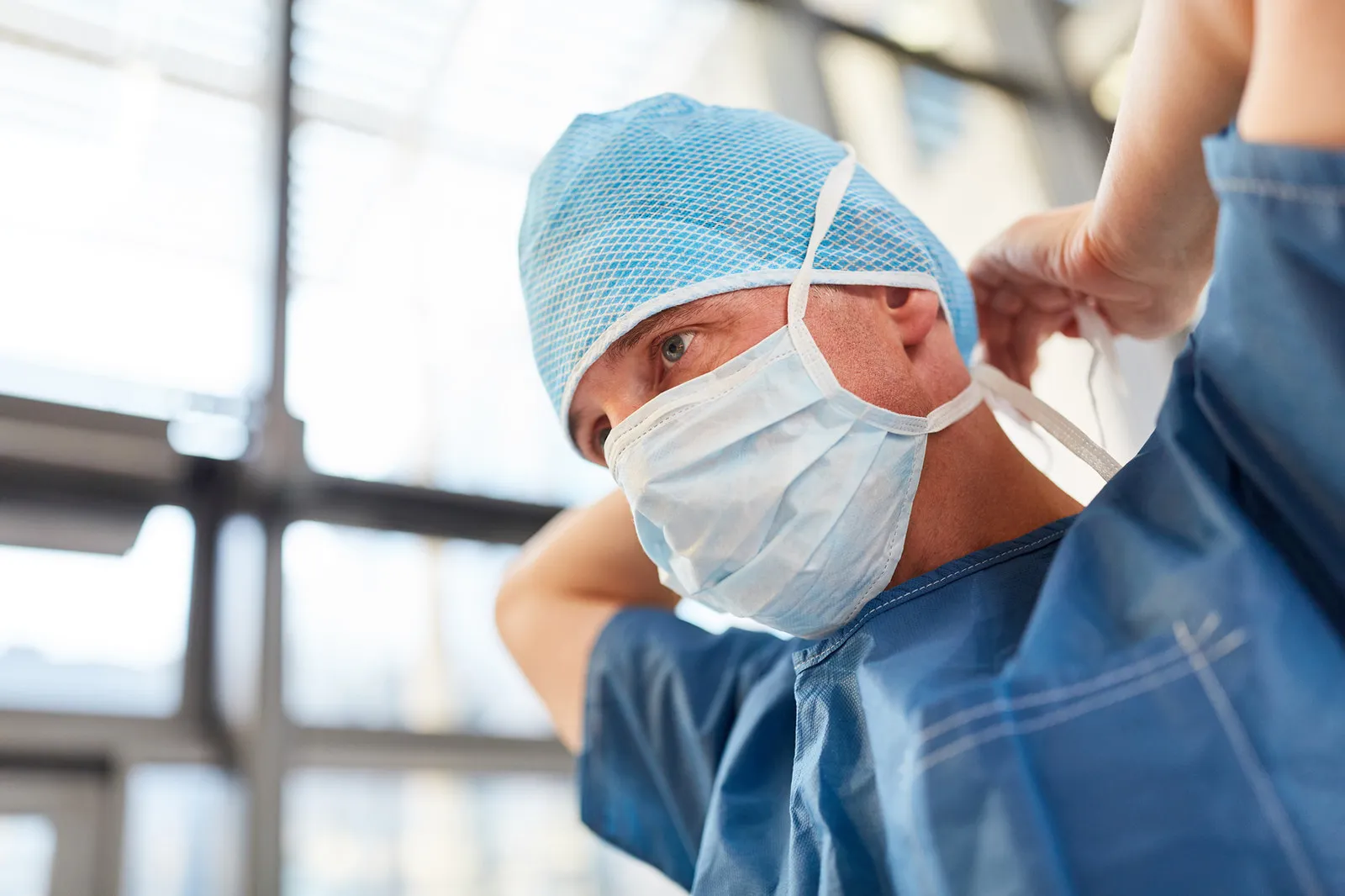 Doctor tying on surgical mask