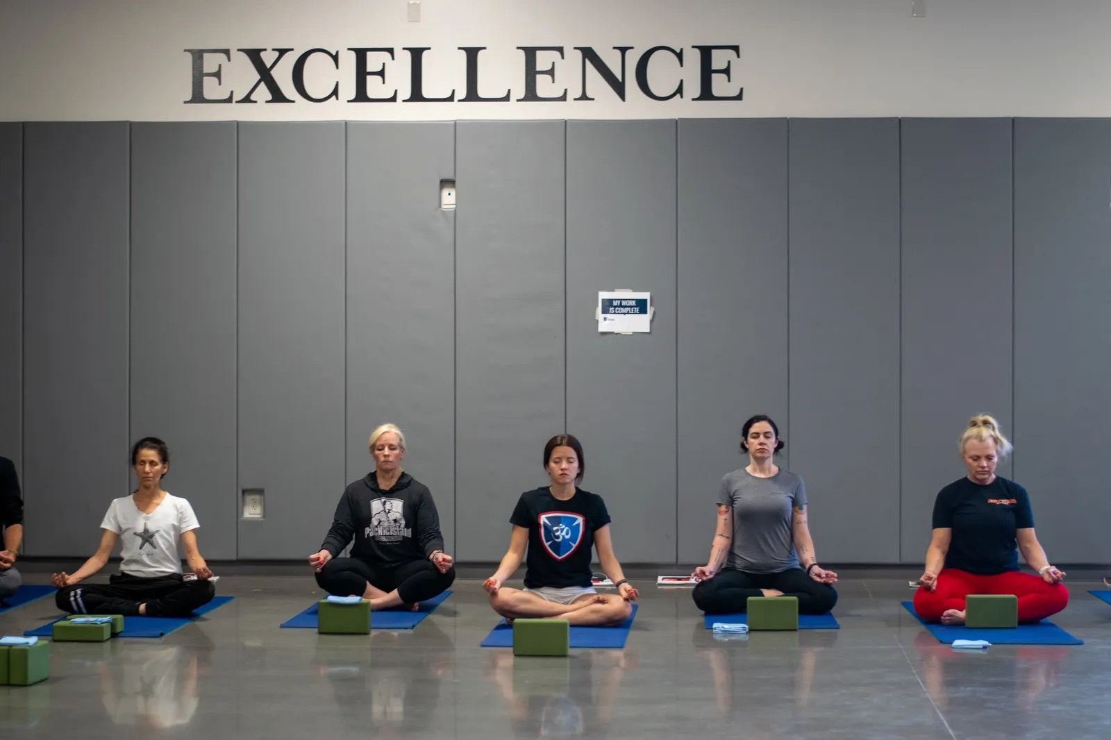 5 yoga students sitting in a cross-legged position