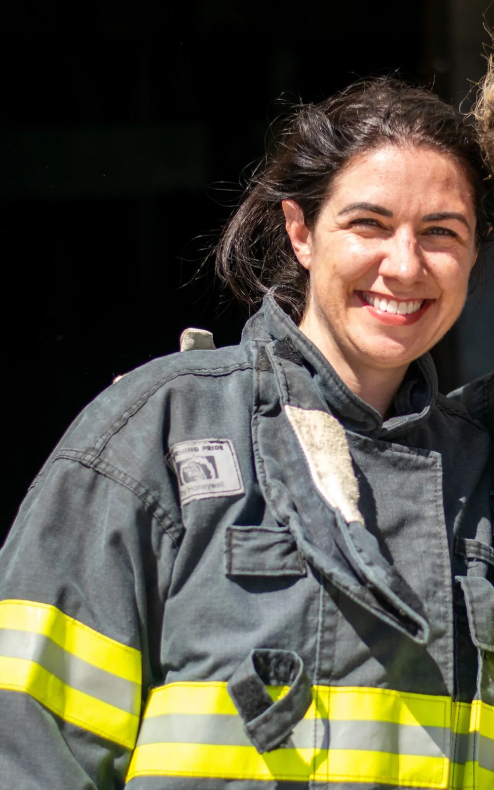 Woman smiling in a firefighter coat