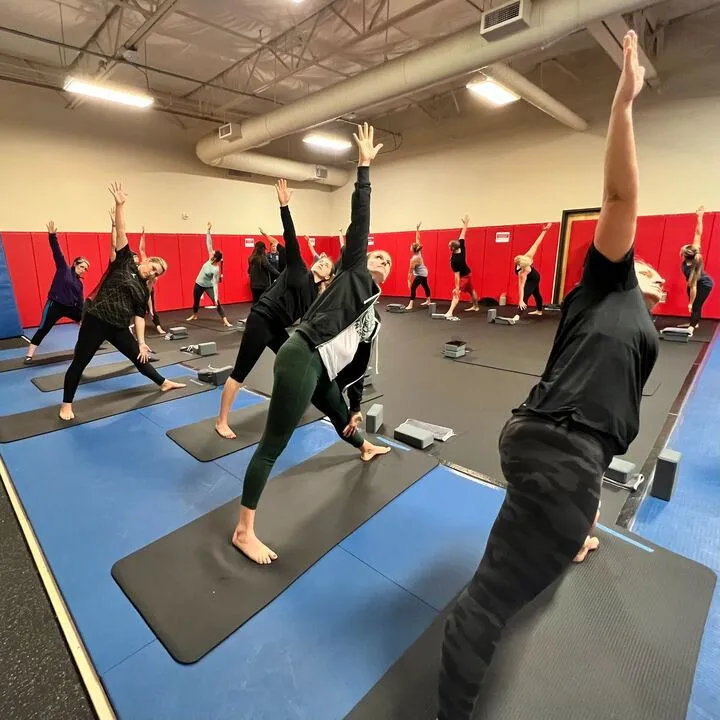 Group of people on yoga mats practicing Triangle Pose